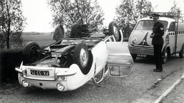 602870 Afbeelding van een over de kop geslagen Renault Dauphine in de Engelenbocht (verbinding tussen de Rijksweg 12 en ...